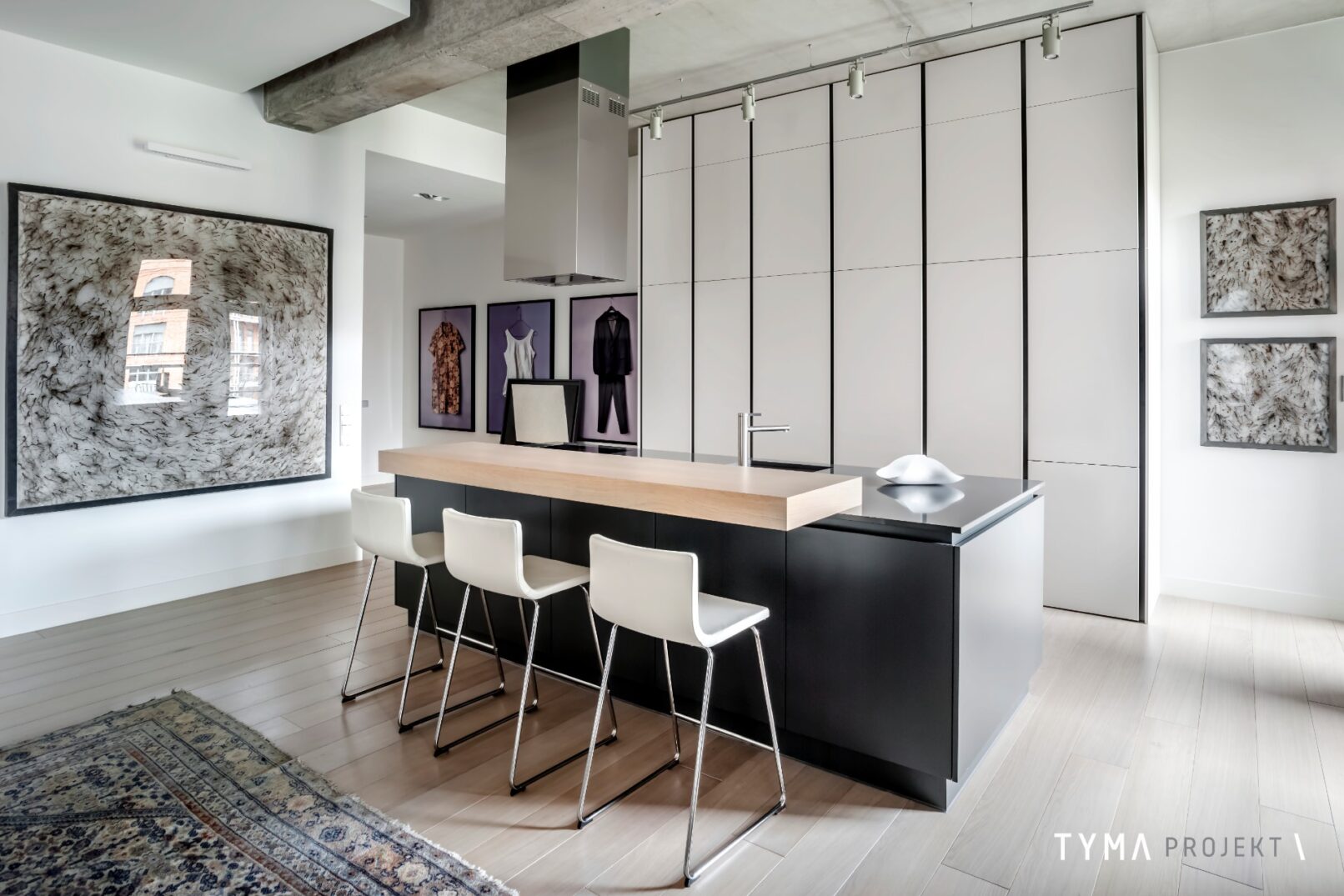 Minimalistyczna kuchnia z nadstawką i hokerami.