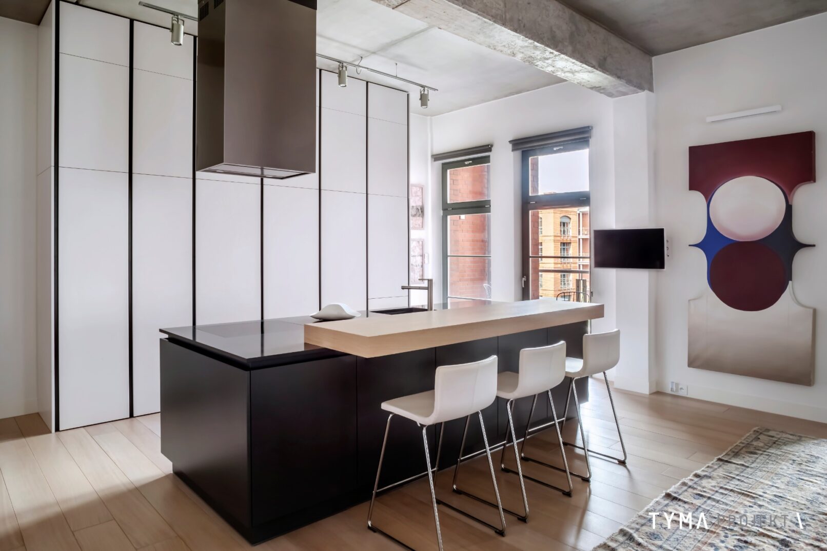 Minimalistyczna kuchnia z nadstawką i hokerami.