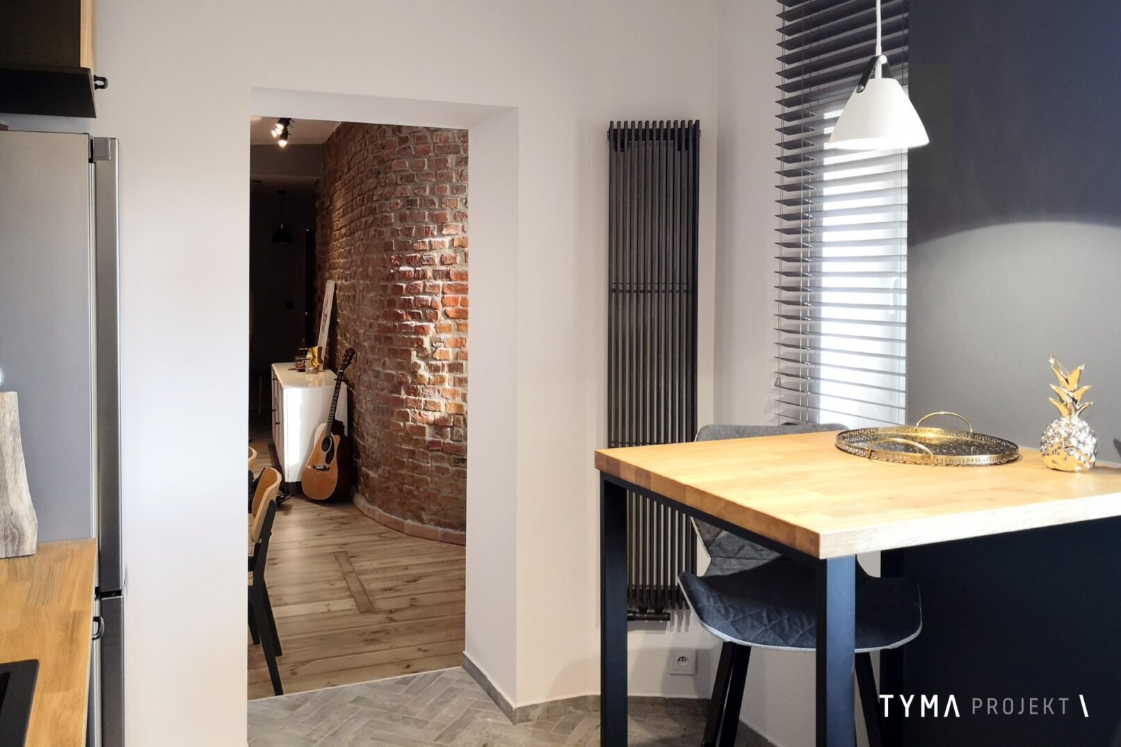 Kameralna kuchnia ze stolikiem barowym.