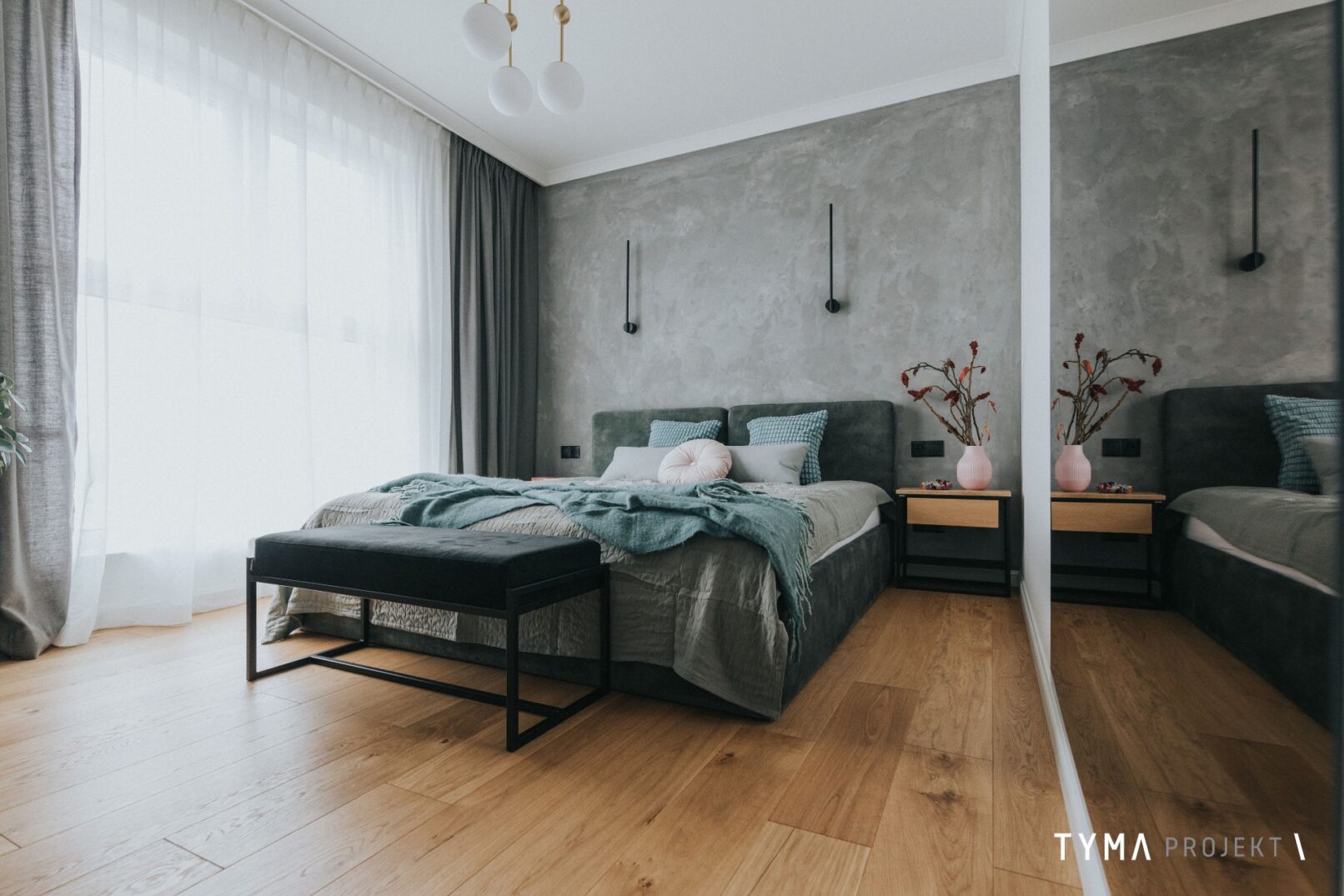 Przestronna sypialnia z dębową podłogą.