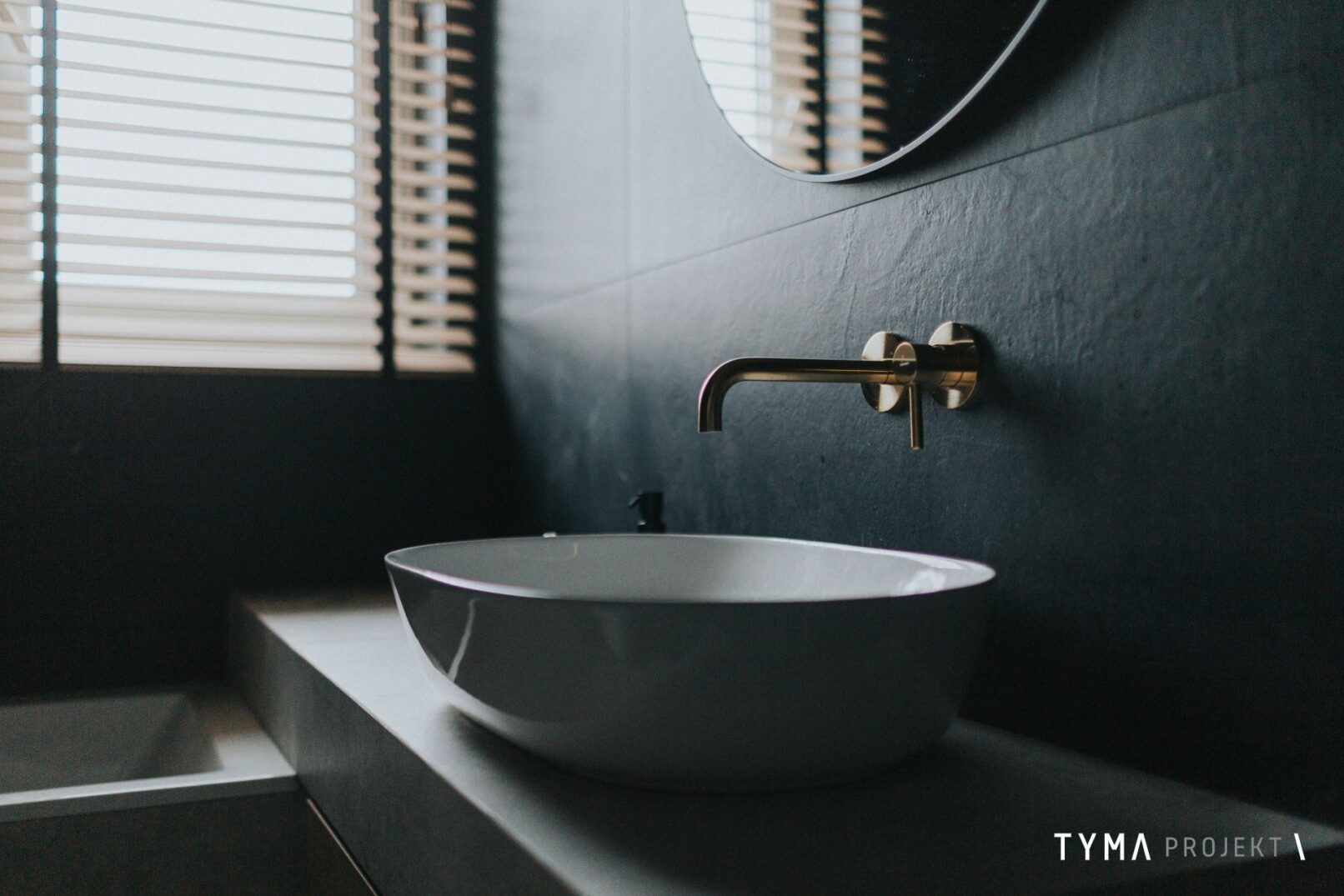 Złota bateria Omnires i umywalka nablatowa.